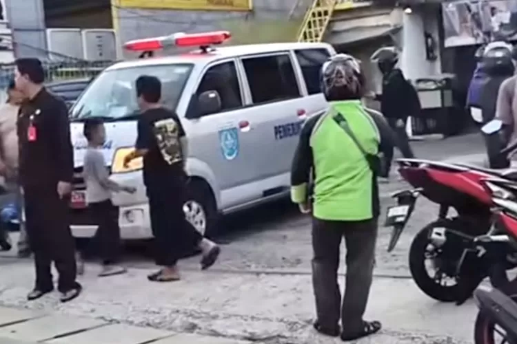 Suasana saat mobil ambulans mengangkut jenazah pengendara motor yang tewas akibat gagal menyalip di Jalan Raya Cinere, Kecamatan Cinere, Kota Depok.  (TANGKAPAN LAYAR)