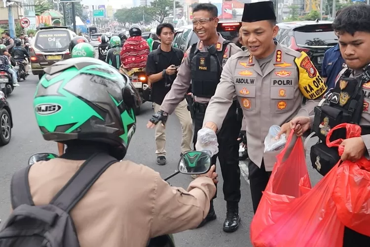 Kapolres Metro Depok, Kombes Abdul Waras bersama komunitas Sahabat Polisi dan Ikatan Motor Indonesia (IMI) Kota Depok, membagikan 2000 paket takjil kepada masyarakat di sekitar persimpangan lampu merah Juanda, Jalan Margonda Raya, Depok, Sabtu (22/3). (Polres Metro Depok)
