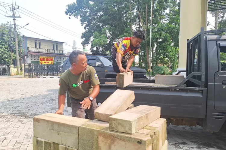 BUDIDAYA : Pekerja saat menurunkan material untuk pembuatan Kolam Ikan Air Tawar di Pekarangan Kantor Kelurahan Duren Mekar, Kecamatan Bojongsari, Kamis (10/4).  (RISKY DWI LESTARI/RADARDEPOK)