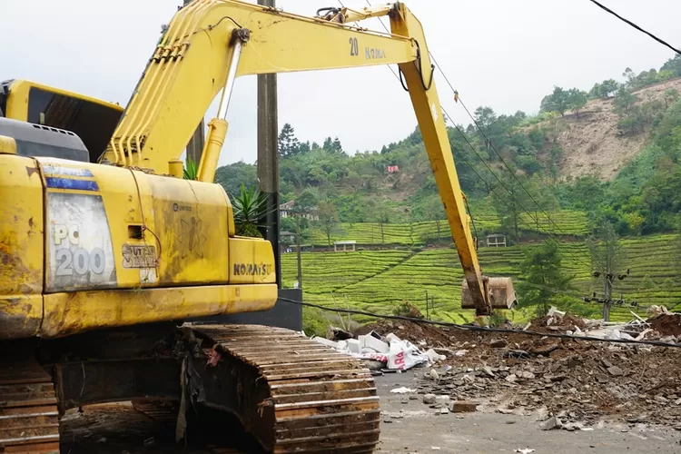 Kendaraan alat berat merobohkan bangunan liar yang berdiri di sepanjang Jalan Raya Puncak, Gunung Mas.  (Istimewa)