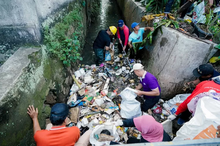 Lurah Tugu, Tri Sakti Anggoro foto bersama warga setelah aksi Jumasih di Bukit Cengkeh di RW 16, Kelurahan Tugu, Kecamatan Cimanggis, Kota Depok, Jumat (2/5). (AGNESYA WIANDA/RADAR DEPOK)
