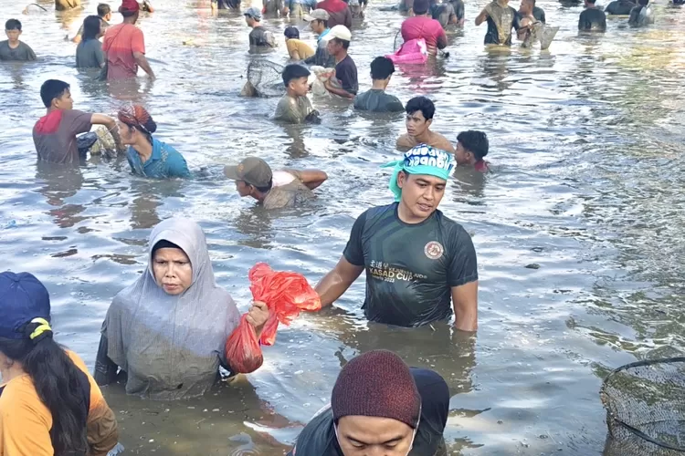 Warga yang sedang mencari ikan, dalam pembukaan Lebaran Depok Ngubek Empang di Jalan Kasiba, Kelurahan Pengasinan, Kecamatan Sawangan, (11/5/2025) (RISKY DWI LESTARI/RADAR DEPOK)
