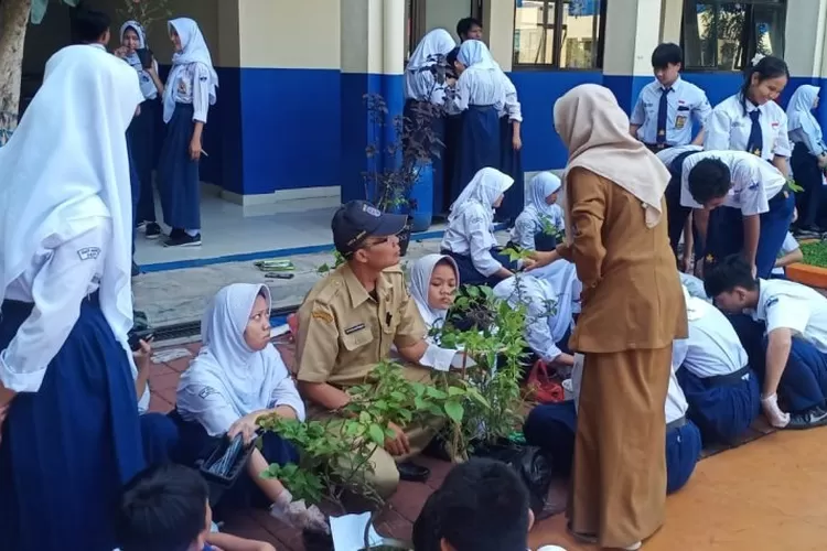 Kepala SMPN 9 Depok, Totong Hardiman sedang memberikan kepada beberapa siswanya terkait cara melawat lingkungam, termasuk pepohonan. (DOKUMEN SEKOLAH)