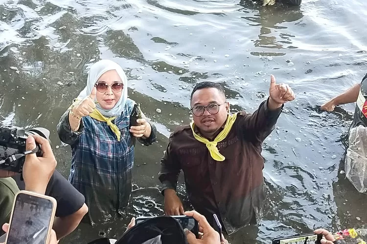 Anggota DPRD Kota Depok, Qonita Lutfiyah (kiri) dan Irfan Rivai (kanan) saat mengikuti Ngubek Empang Lebaran Depok 2025 di Kelurahan Pengasinan, Kecamatan Sawangan, Minggu (11/5).  (DOKUMEN QL CENTER)