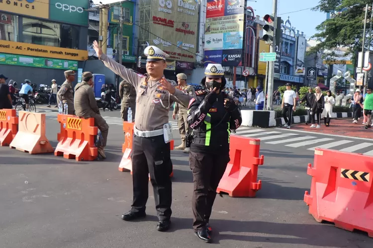 Polisi saat Pengamanan CFD Kedua Kota Depok di lintasan jantung kota Depok, Jalan Margonda Raya, Kelurahan Kemiri Muka, Kecamatan Beji, Minggu (11/5) Pagi.  (RISKY DWI LESTARI/RADAR DEPOK)