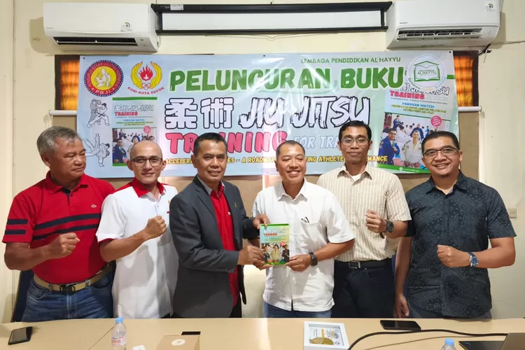 Ketua Umum KONI Kota Depok, Herry Suprianto menerima buku Jiujitsu Training For Trainer : Panduan Materi Percepatan Untuk Asisten Pelatih dan Materi Prestasi Atlet, dari Hero Amor Patria, saat soft launching berlangsung di Gedung KONI Kota Depok, Rabu (21/5).  (JUNIOR/RADAR DEPOK)