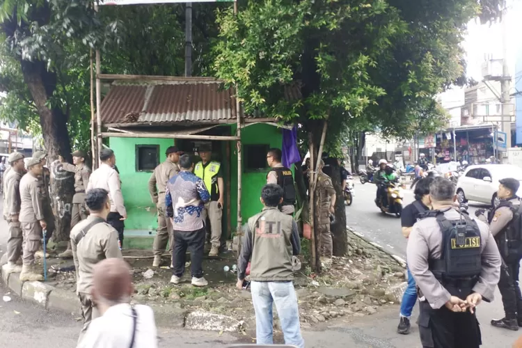 Aparat gabungan membongkar salah satu posko ormas diatas lahan hijau, Jalan Proklamasi, Kecamatan Sukmajaya, Kota Depok, Jumat (23/5). (AGNESYA WIANDA/RADAR DEPOK)