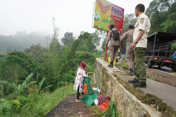 Pedagang bersembunyi di tembok badan jalan saat Satpol PP melakukan penataan. (Istimewa)