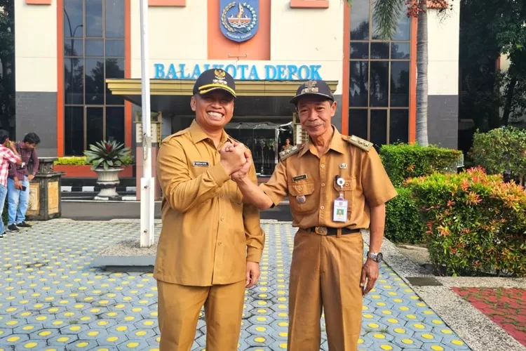 PENUH HARU : Lurah Purnabakti Kelurahan Curug Hasan (kanan) dan Walikota Depok Supian Suri (kiri) setelah apel pagi di balaikota saat menjabat tangan di hari apel terakhir sebelum memasuki masa Purnabakti. (Istimewa)