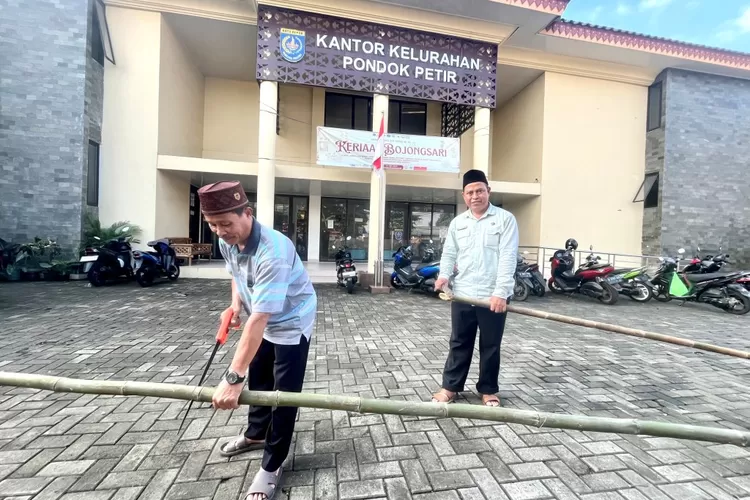 Bambu yang tengah dipotong salah satu kasi Kelurahan Pondok Petir H Tarojih dan Ketua lingkungan RW, guna persiapan pembuatan umbul umbul di Kelurahan Pondok Petir, Kecamatan Bojongsari, Kamis (10/7).  (RISKY DWI LESTARI/RADAR DEPOK)
