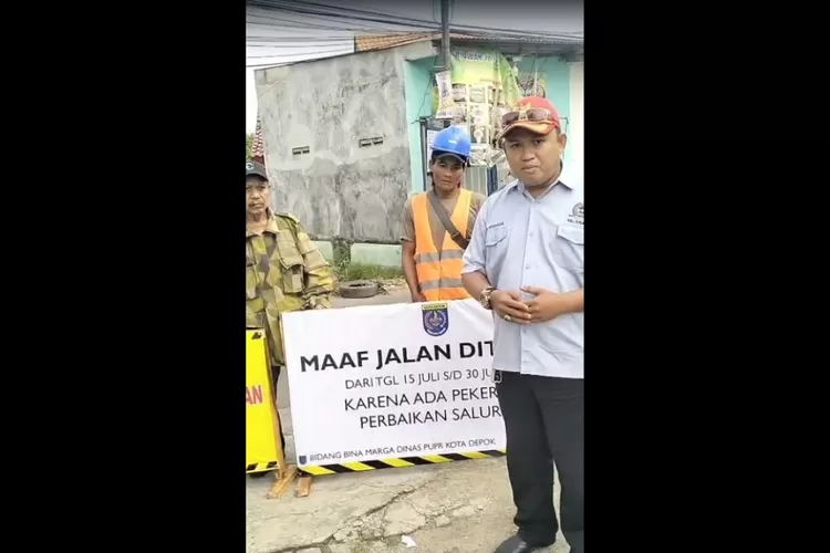 LPM Kalibaru, Rudi mengimbau warga untuk menghindari jalan Abdul Gani, karena ada perbaikan saluran air selama dua pekan, Kelurahan Kalibaru, Kecamatan Cilodong, Kota Depok, Selasa (15/7). (AGNESYA WIANDA/RADAR DEPOK)