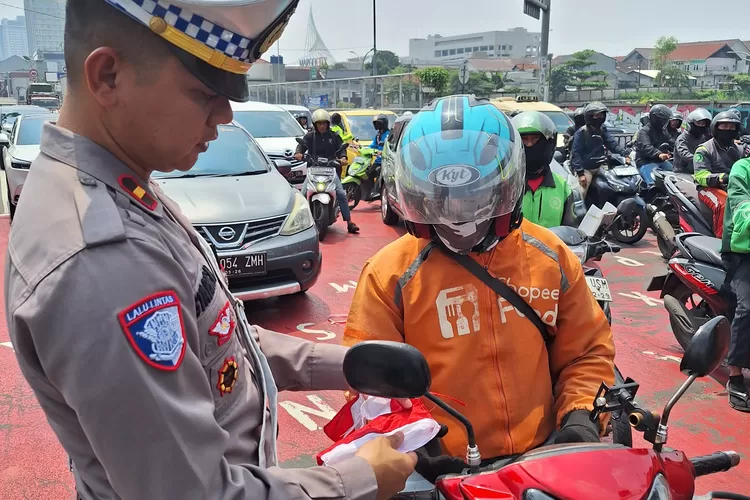 Satlantas Polres Metro Depok melalui Unit Kamsel melaksanakan kegiatan Pendistribusian Bendera Merah Putih dan Polisi Lalu Lintas Menyapa yang berlangsung di sekitar Traffic Light M9, Jalan Margonda Raya, Kecamatan Beji, Kota Depok, Kamis (7/8).  (RISKY DWI LESTARI/RADAR DEPOK)