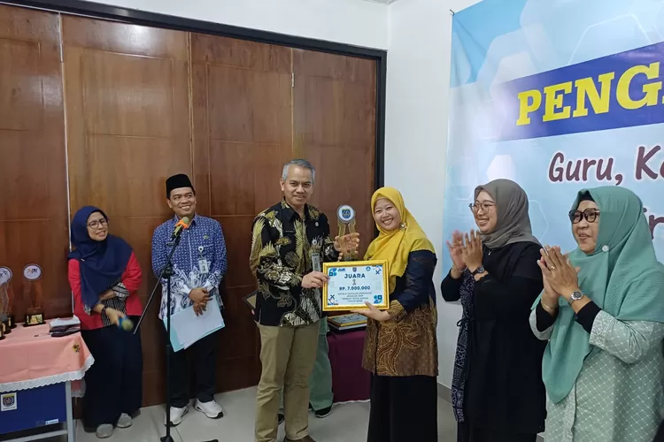 Kepala Bidang Pembinaan SMP, Disdik Depok, M Yusuf memberikan penghargaan kepada kepala SMPN 34 Depok atas raihan Juara 1 Kepsek Inspiratif 2025 tingkat Kota Depok, beberapa waktu lalu.&nbsp; (ANDIKA EKA/RADAR DEPOK)