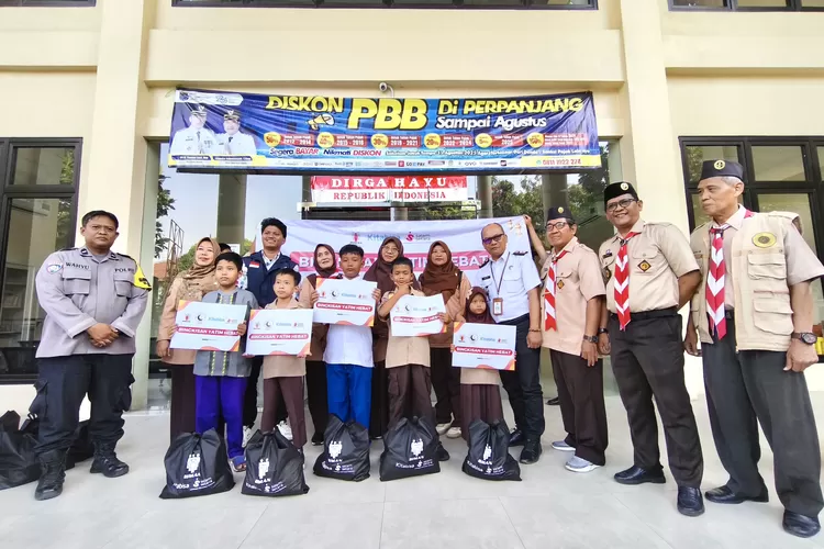 Lurah Beji Timur, Sobarudin (tengah kanan, berbaju putih) saat disambangi Kwarran Ranting Kecamatan Beji dan Biman Fondation untuk menyalurkan paket bantuan kepada 90 anak yatim, Rabu (27/8). (RISKY DWI LESTARI/RADAR DEPOK)
