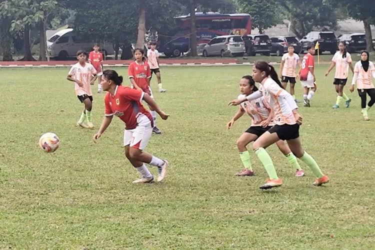 Pemain Kabupaten Bogor berusaha menghindari kejaran tim sepakbola Kabupaten Sukabumi.