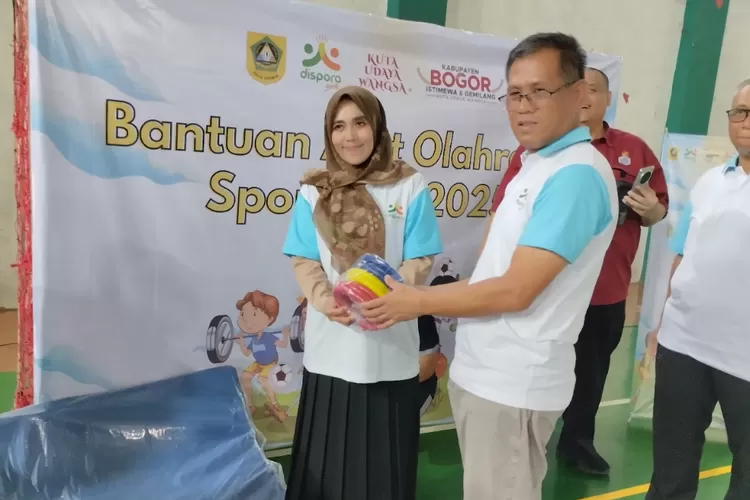 Kadispora Kabupaten Bogor Asnan AP (kanan) menyerahkan secara simbolis bantuan alat olahraga SportKids kepada salah satu perwakilan guru di GOM Cileungsi pada Selasa, 9 September 2025.