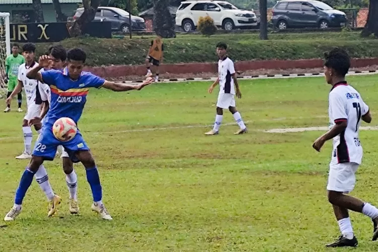 Pemain Kabupaten Cianjur berusaha menghalangi pemain Kabupaten Bogor.