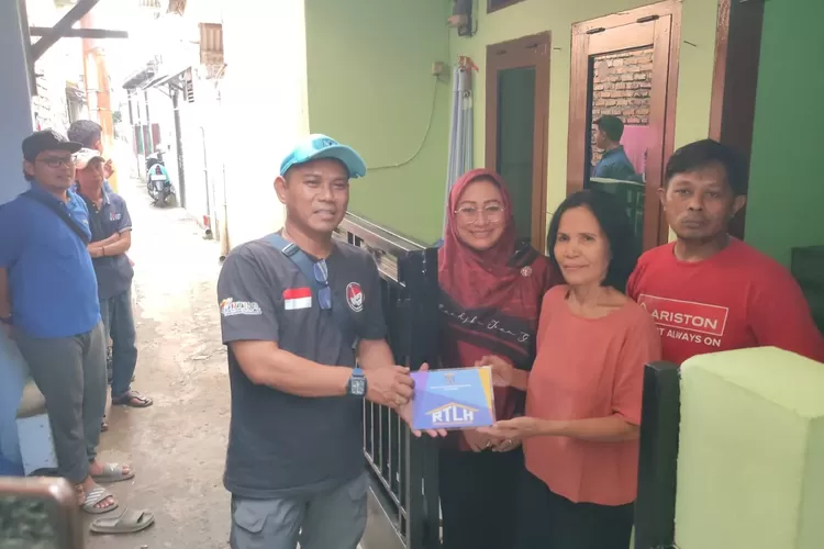 Wakil Ketua DPRD Yuni Indriany melakukan pemaangan plakat RTLH di salah satu rumah warga yang mendapatkan bantuan di Kelurahan Bojong Pondok Terong, Kecamatan Cipayung, Kota Depok, beberapa waktu lalu. (AGNESYA WIANDA/RADAR DEPOK)
