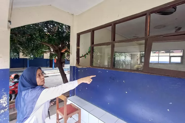 Waka Humas SMPN 28 Depok, Rosenny Damanik menunjuk kerusakan pada kelas yang ada di sekolahnya. (ANDIKA EKA/RADAR DEPOK)