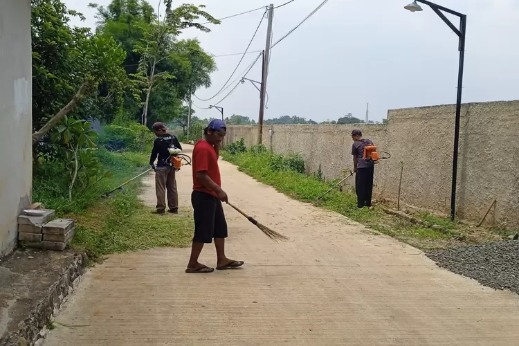 RW1 Kelurahan Duren Seribu, Musli, bersama warga membersihkan jalan utama arco raya dan sekitaran lainnya di wilayah Kelurahan Duren Seribu, Kecamatan Bojongsari, Kota Depok, Rabu (15/10). (RISKY DWI LESTARI/RADAR DEPOK)
