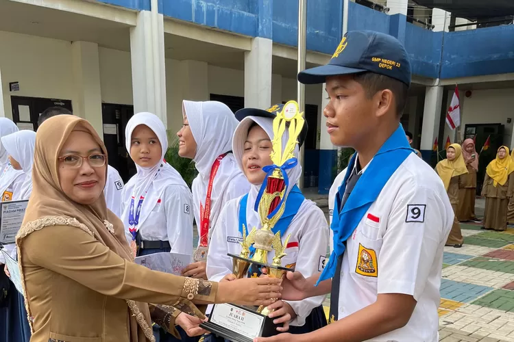 Kepala SMPN 23 Depok, Sukmawaty Zulkifli memberikan penghargaan kepada siswa nya yang berprestasi, di halaman sekolahnya, Senin (20/10) (ANDIKA EKA/RADAR DEPOK)