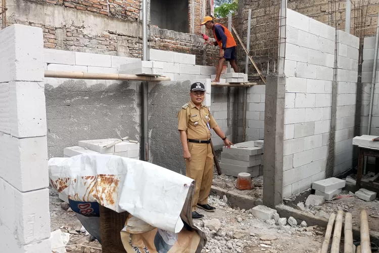 Lurah Pancoranmas, Moh Soleh dan Kasi Ekbang Kelurahan Pancoranmas Agus S saat meninjau langsung proses salah satu pembangunan fisik di Posyandu melur RT2/11 Kelurahan Pancoranmas, Rabu (29/10).  (RISKY DWI LESTARI/RADAR DEPOK)