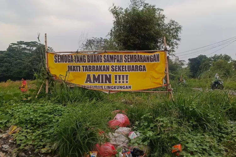 Penampakan spanduk peringatan di kawasan Tanah Merah, Kelurahan Cipayung Jaya, Kecamatan Cipayung, Kota Depok yang kerap dijadikan lokasi pembuangan sampah sembarangan. (ALDY RAMA/RADAR DEPOK)