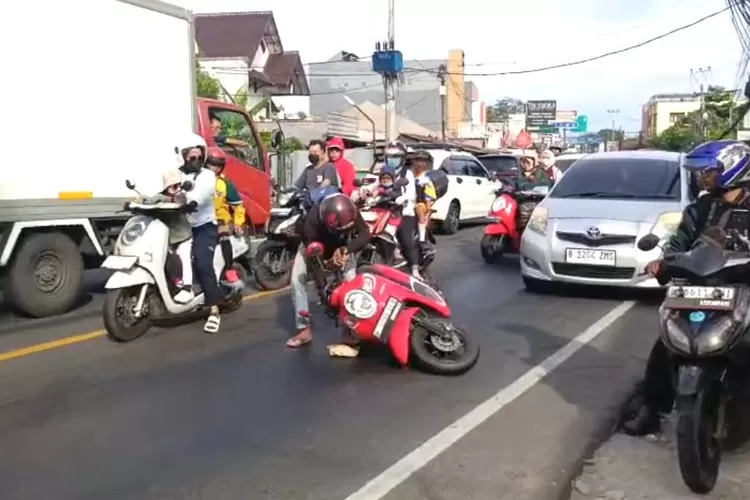 Pengendara motor yang melintas di Jalan Sawangan Raya, tepatnya di depan RS Bhakti Yudha saat terjatuh dari kendraannya akibat ceceran oli, Kamis (6/11). (RISKY DWI LESTARI/RADAR DEPOK)