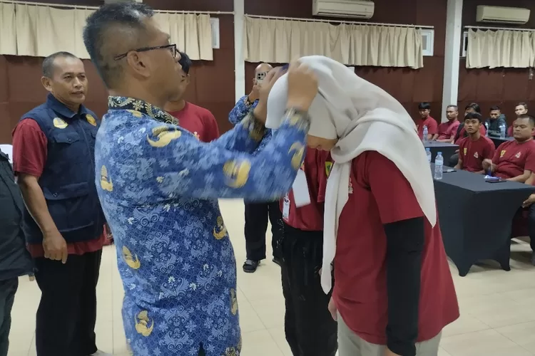 Kadispora Kabupaten Bogor Asnan AP menyematkan tanda peserta bimtek ortrad di Grand Pesona, Kecamatan Caringin pada Senin, 17 November 2025, malam WIB.