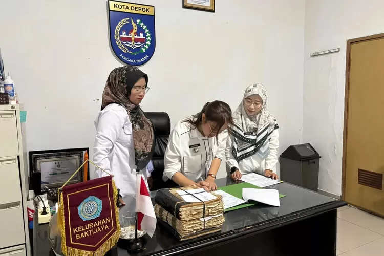 Camat Sukmajaya, Christine Desima Arthauli (tengah) saat penandatanganan serah terima arsip digital Letter C di Kantor Kelurahan Baktijaya, Rabu (19/11). (DOKUMEN PEMKOT DEPOK)