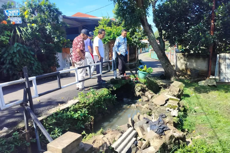 Lurah Curug Bojongsari Ahmad Sofyan, (batik biru) didampingi Ketua LPM Curug Bojongsari, Herman Karno (baju putih tengah) saat meninjau kerusakan drainase RT3/10 Kelurahan Curug, Kecamatan Bojongsari, Kota Depok, Jumat (5/12). (RISKY DWI LESTARI/RADAR DEPOK)