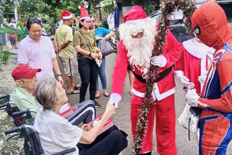 Seorang pria berkostum Santa Claus saat membagikan hadiah natal kepada umat Kristiani di Bellacasa Residence, Kelurahan Depok, Kecamatan Pancoranmas, Sabtu (6/12). (GERARD SOEHARLY/RADAR DEPOK)