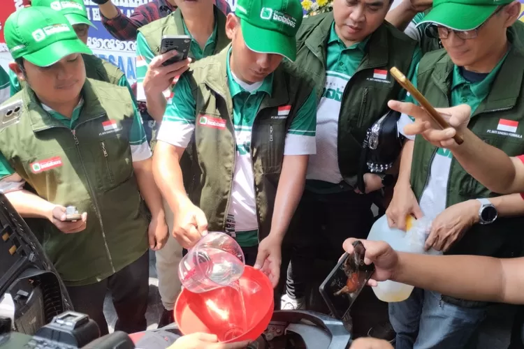 Tim dari Bobibos menuangkan bahan bakar nabati yang dikembangkannya ke salah satu motor saat launching di Jonggol pada Minggu, 2 November 2025.