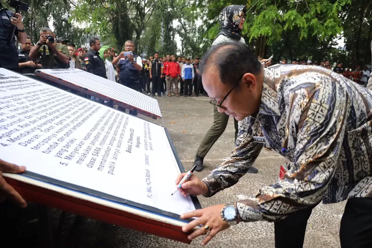 Pj Wali Kota Bekasi Raden Gani Muhamad menandatangani deklarasi Pemilu Damai 2024 bersama unsur Ormas dan LSM. (Pemkot Bekasi)
