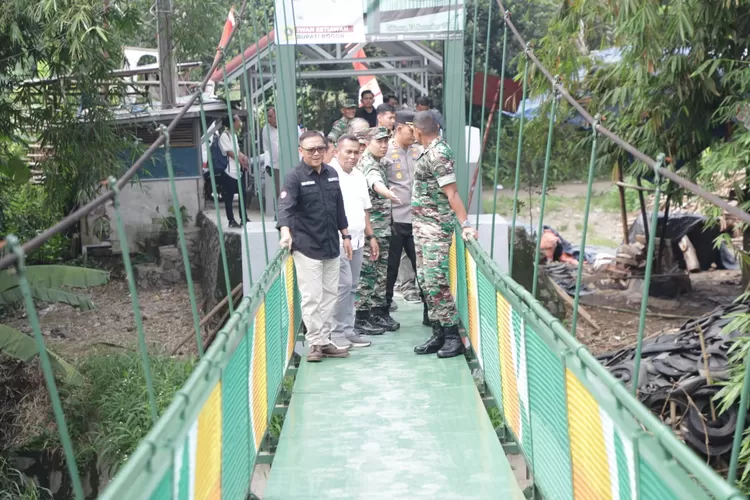 Danrem 061/Surya Kencana Brigjen TNI Anan Nurakhman didampangi Bupati Bogor Iwan Setiwan usai meresmikan pembangunan jembatan rawayan di Kelurahan Karadenan. (Foto: Devina)