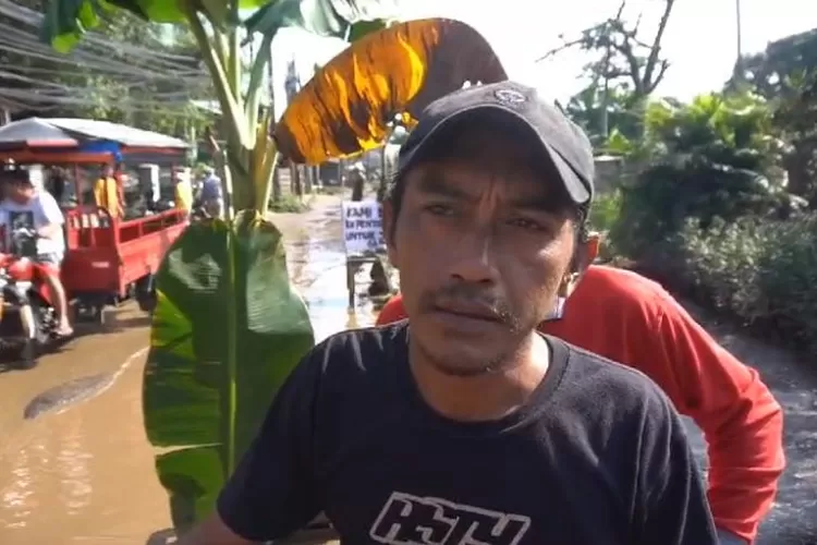 Sejumlah warga di Kecamatan Gunungputri menggelar aksi unjuk rasa karena geram jalan rusak yang tak kunjung diperbaiki dan menganggap jalan tersebut lebih layak jadi lokasi ternak lele karena kerap tergenang air. (Foto: Devina)