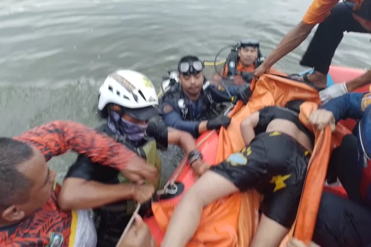 Petugas BPBD Kabupaten Bogor saat melakukan evakuasi kepada seorang bocah yang tewas saat bermain di Setu Rawa Sudat Kecamatan Gunungputri.