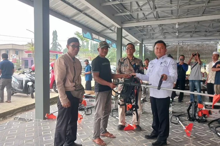 Kades Palasari menyerahkan secara simbolis Satu alat mesin rumput ke ketua RW, disaksikan camat Cijeruk M. Sobar Mansoer (Anto/Metropolitan )