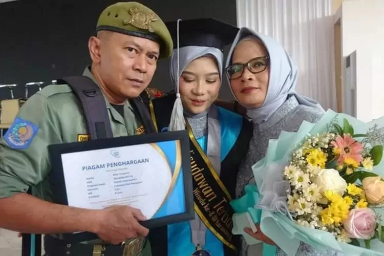 Senyum pria berseragam hansip ini merekah saat menyaksikan anak perempuannya diwisuda dengan predikat cumlaude (Samsudin)