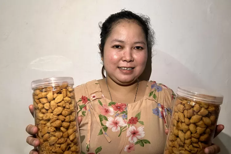 Neneng menunjukan kue hasil produksinya sendiri. 