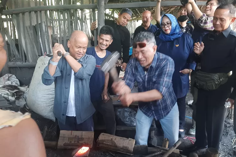 Bakal Calon Gubernur Jabar dari Nasdem, Ilham Akbar Habibie mencoba menempa besi yang akan dijadikan golok ddi Desa Mekarmaju, Kecamatan Pasirjambu, Kabupaten Bandung, Kamis, 11 Juli 2024. (Putra  Wahyu Purnomo)