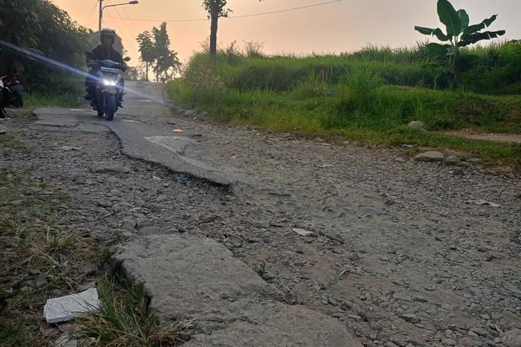 Pengendara roda dua tampak menghindari bagian jalan rusak saat melintas jalan Sawah Lega, Desa Bungurjaya, Kecamatan Pondoksalam, Kabupaten Purwakarta, Selasa 30 Juli 2024. (Aik/Metropolitan)