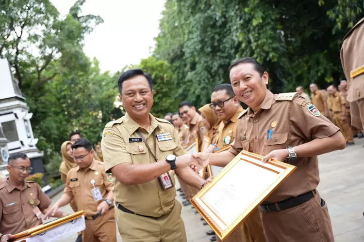 Dari Kiri, Kepala BKPSDM Kabupaten Purwakarta Wahyu Wibisono saat menyerahkan piagam penghargaan juara LCCA dan Paduan Suara Aparatur, di Taman Mayar Datar, komplek Setda Kabupaten Purwakarta, Senin 5 Agustus 2024 (Aik/Metropolitan)