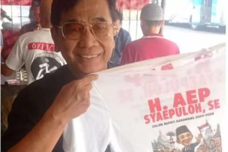 beredar foto Anggota BPD Desa Cikampek Utara Aep Saeful Rohman sedang memegang baju bergambar bakal Calon Bupati Karawang Aep Syaepuloh di media sosial (isitmewa)