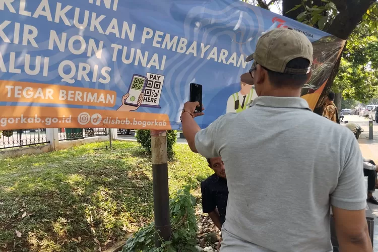 Warga saat melakukan pembayaran non tunai parkir di Jalan Tegar Beriman, Cibinong, Kabupaten Bogor, Selasa, 17 September 2024. (Erwin)