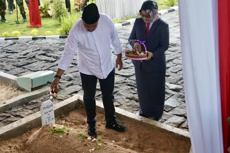 Rudy Susmanto menaburkan bunga saat pemindahan makam orang tuanya di Pendopo Pelataran Patriot, Perumahan Puri Nirwana Estate, Cibinong, Kabupaten Bogor, Selasa 21 Januari 2025. (Arifin/Metropolitan)