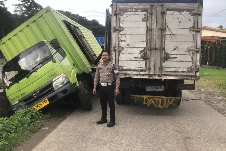 Kecelakaan truk terperosok ke gorong-gorong saat menyalip gerobak penjual cireng di Sentul, Kabupaten Bogor. (Polres Bogor)