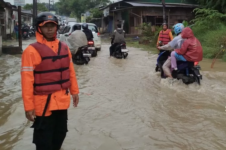 Petugas BPBD Kabupaten Bogor saat melakukan penanganan banjir di Jalan Raya Klapanunggal, Desa Klapanunggal, Kecamatan Klapanunggal, Kabupaten Bogor tergenang banjir, Selasa, 28 Januari 2025. (BPBD Kabupaten Bogor)