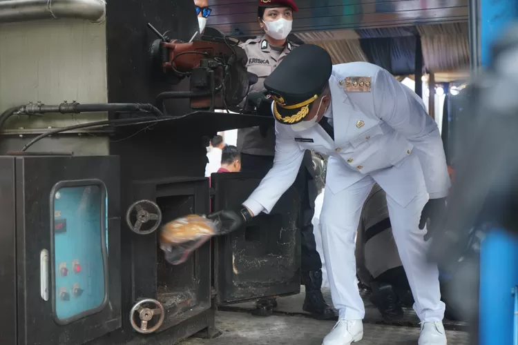 Bupati Bogor Rudy Susmanto memasukan barang bukti narkoba ke alat pemusnah di Polres Bogor, Kamis, 20 Februari 2025. (Arifin/Metropolitan)