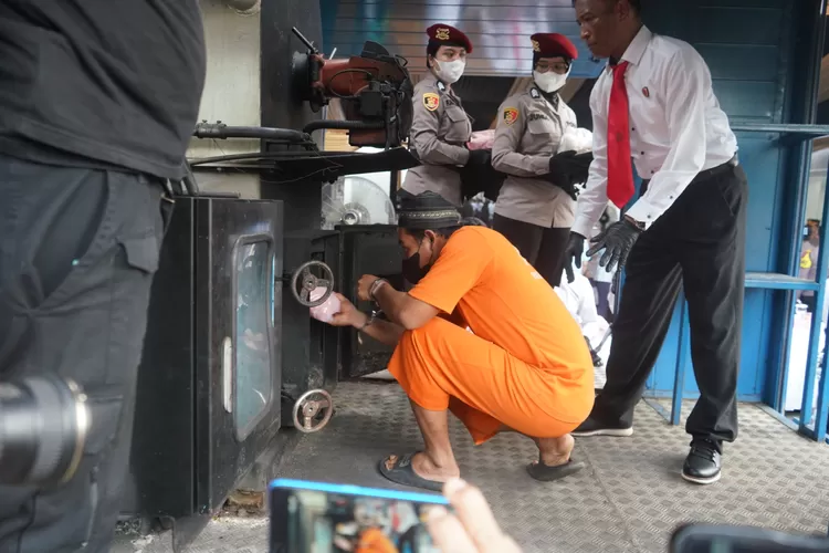 Tersangka memasukan barang bukti narkoba ke dalam alat pemusnah saat pemusnahan narkoba di Polres Bogor, Kamis, 20 Februari 2025. (Arifin/Metropolitan)